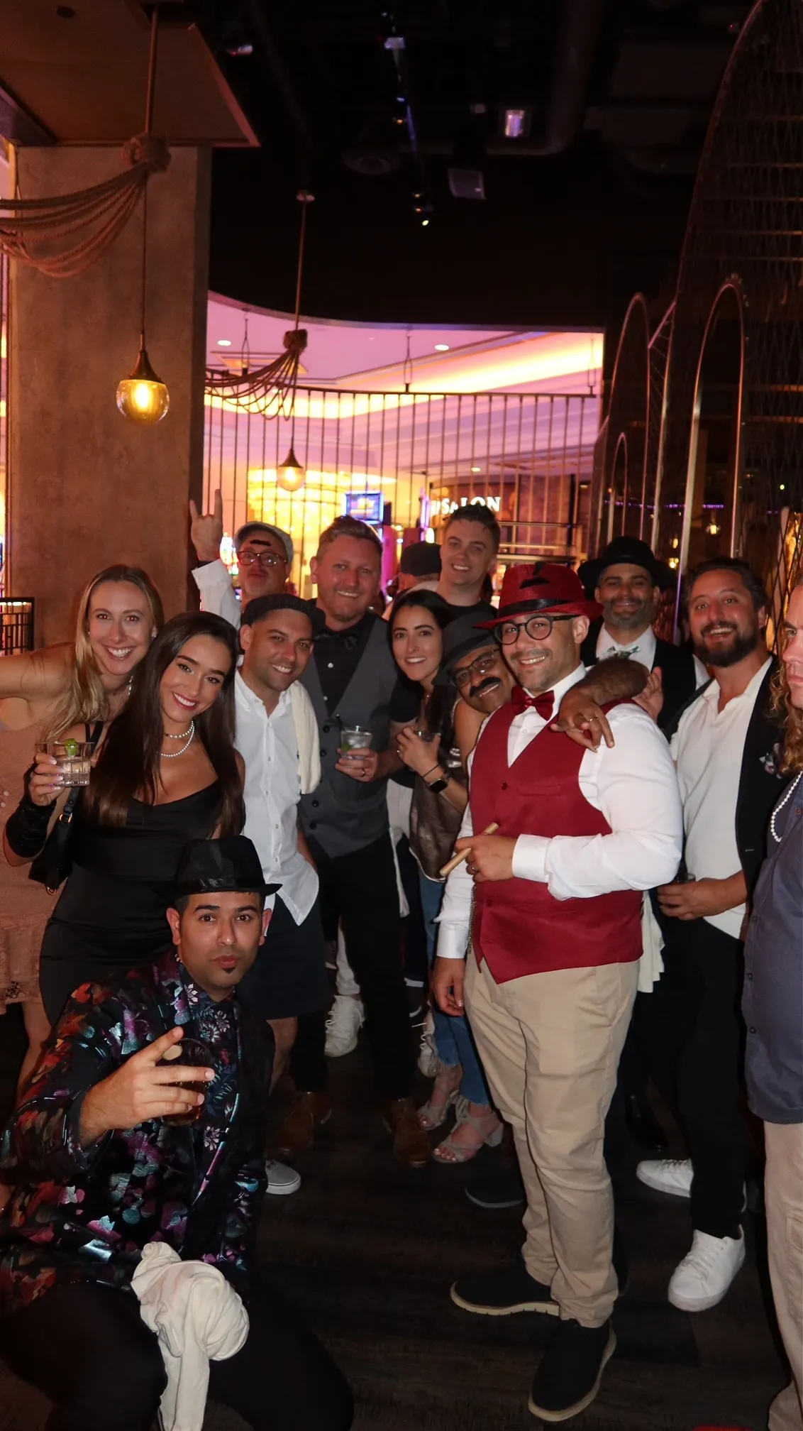 A group dressed for an evening out, several wearing colorful jackets and hats.